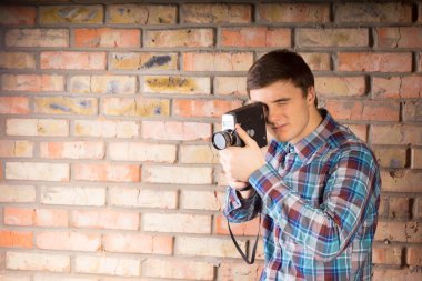 Young Man Capturing Something Using Camera clipart