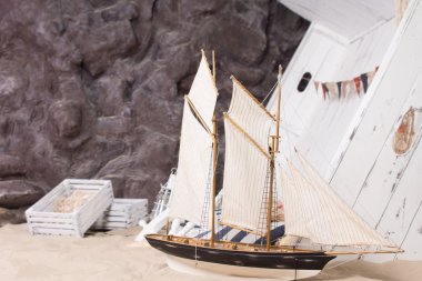 Toy yacht and wrecked wooden ship clipart