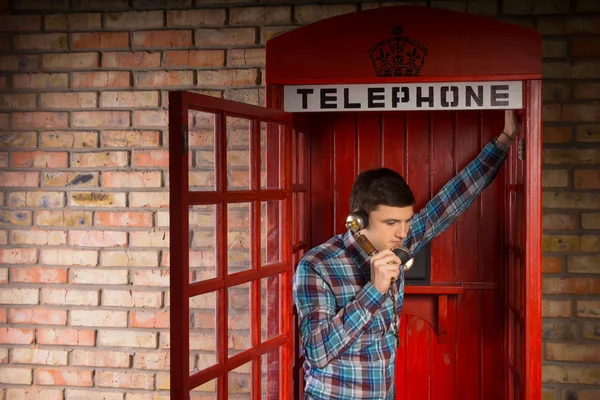 Uomo in chat all'interno di una cabina telefonica rossa — Foto Stock