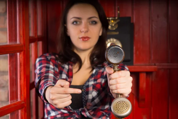 Woman wijzend naar een vintage telefoon handset — Stockfoto