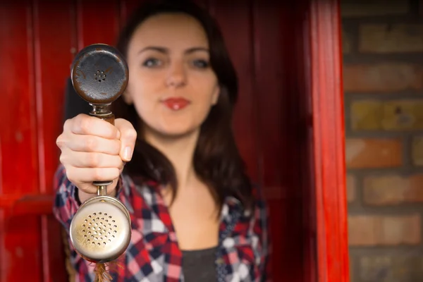 Jonge vrouw presenteren een telefoonhoorn — Stockfoto