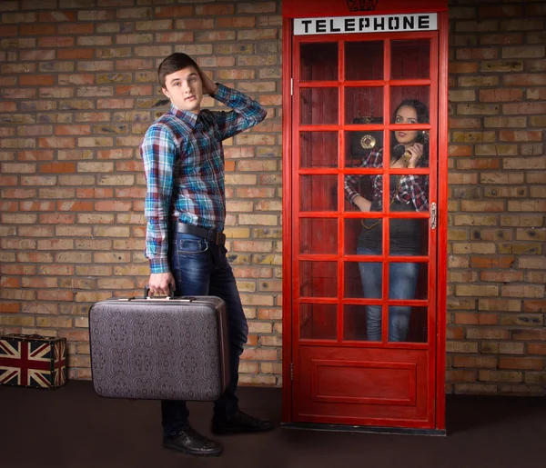 Man met koffer wachten op de telefooncel — Stockfoto