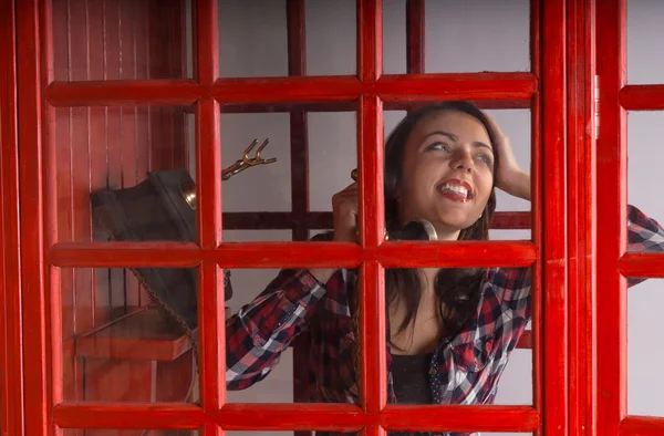 Feliz joven mujer charlando en un teléfono público — Foto de Stock