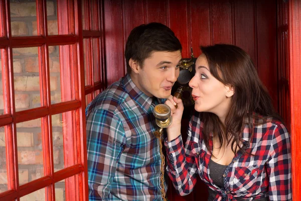 Young couple gossiping on the phone — Stock Photo, Image