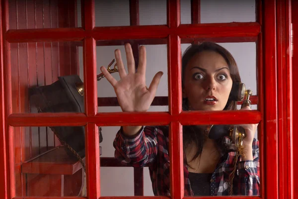 Terrified woman trapped in a telephone booth — Stock Photo, Image