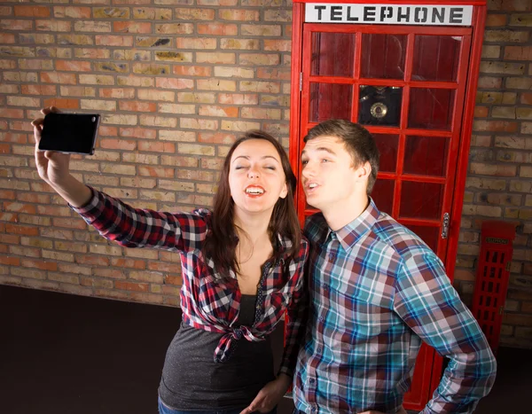 Tourists posing in front of a British phone booth — Stock Photo, Image