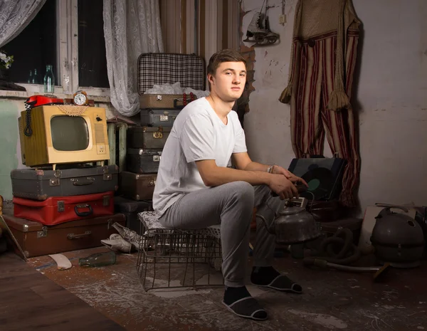 Sitting Man at the Junk Room Looking at Camera — Fotografie, imagine de stoc