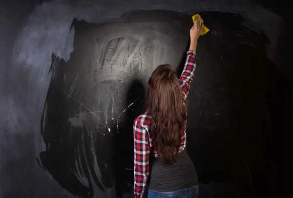 Young teacher or student cleaning the blackboard — Stock Photo, Image