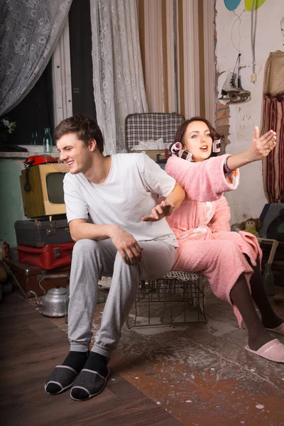 Casal sentado na sala abandonada com palmas abertas — Fotografia de Stock