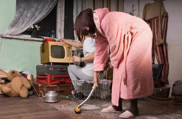 Mulher de roupão rosa limpando um quarto bagunçado — Fotografia de Stock
