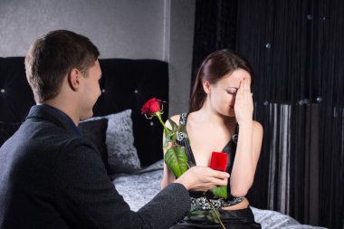 Man Proposing to Woman with Rose and Ring