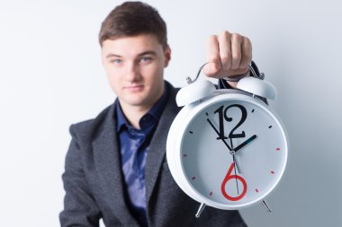 Çalar saat kameraya gösteren genç adam
