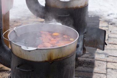 Bir açık ahşap brülör soba üzerinde yemek yemek