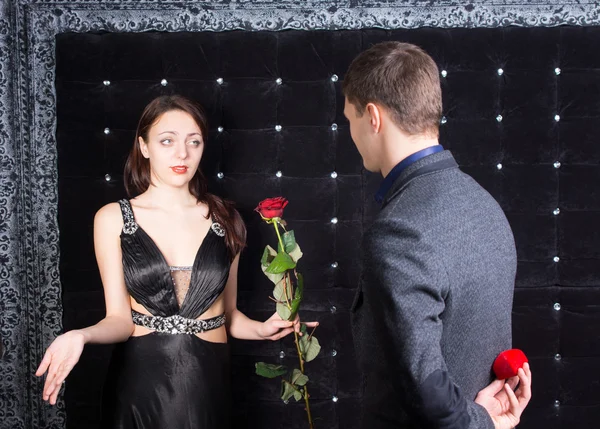 Jeune homme offrant une fleur à dame malheureuse — Photo