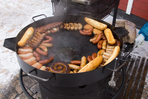 Variety of sausages grilling on an open griddle — Stock Photo, Image