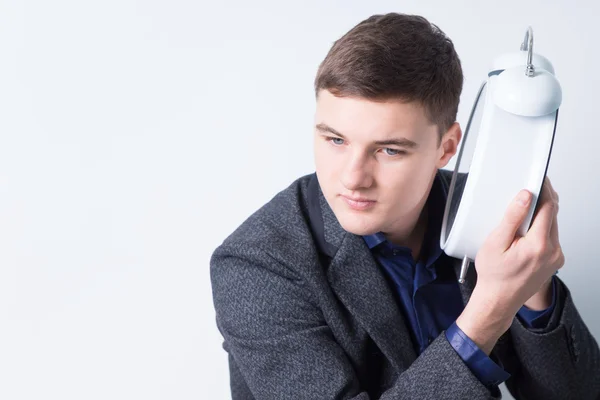 Curioso empresario escuchando el sonido del reloj despertador — Foto de Stock