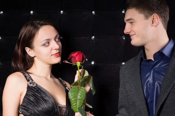 Loving couple smiling over a red rose Stock Photo