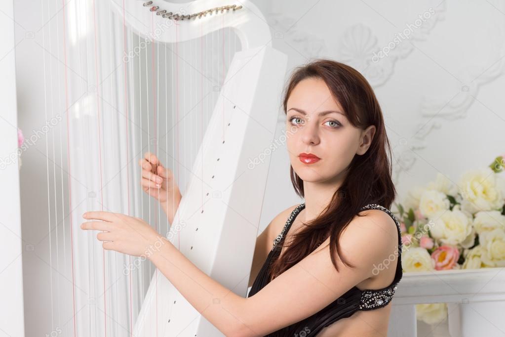 Pretty harpist playing her harp