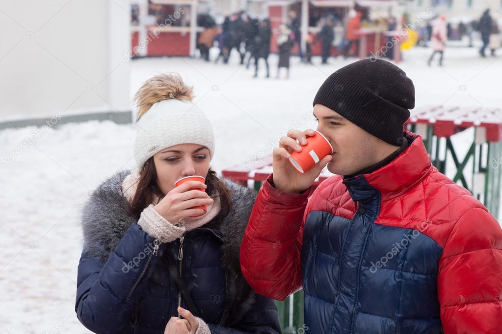 Young couple sipping hot drinks on a cold day