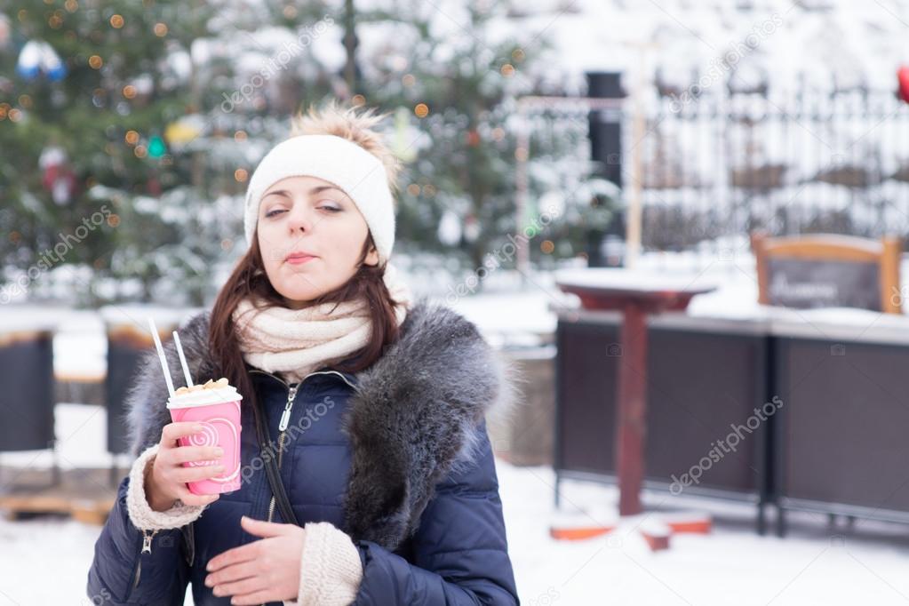 Young woman enjoying a hot drink in winter