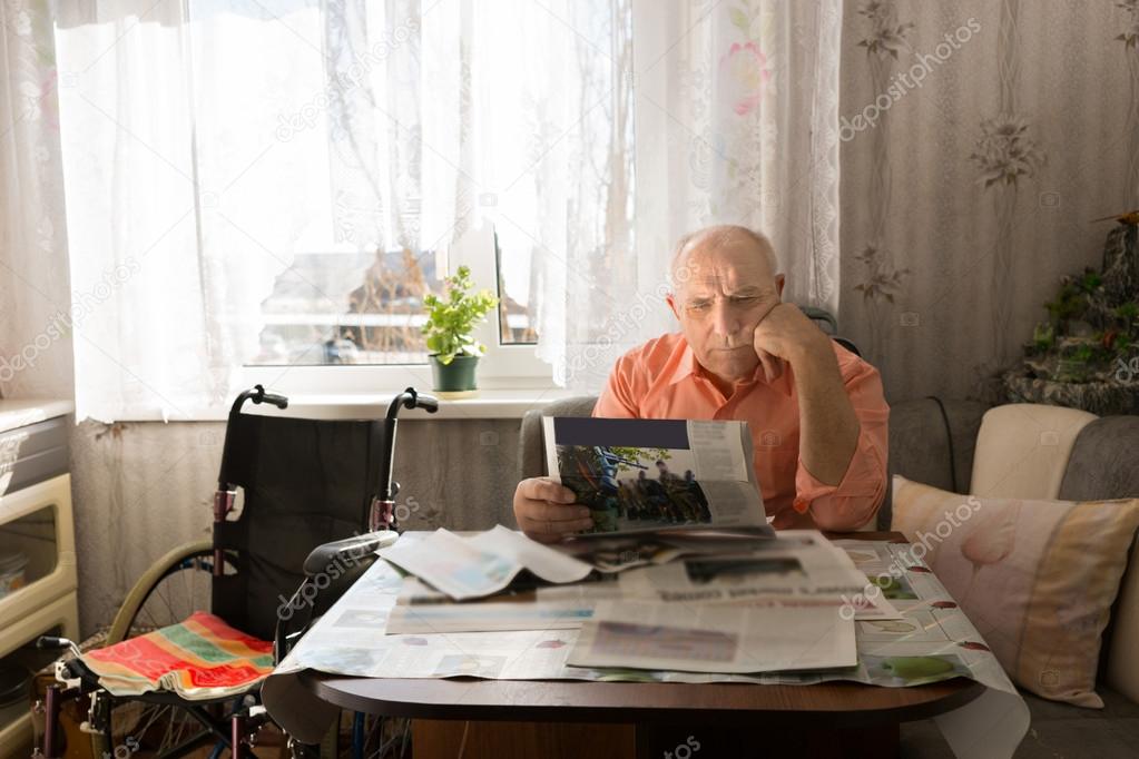 Serious Old Man Reading News on Tabloids