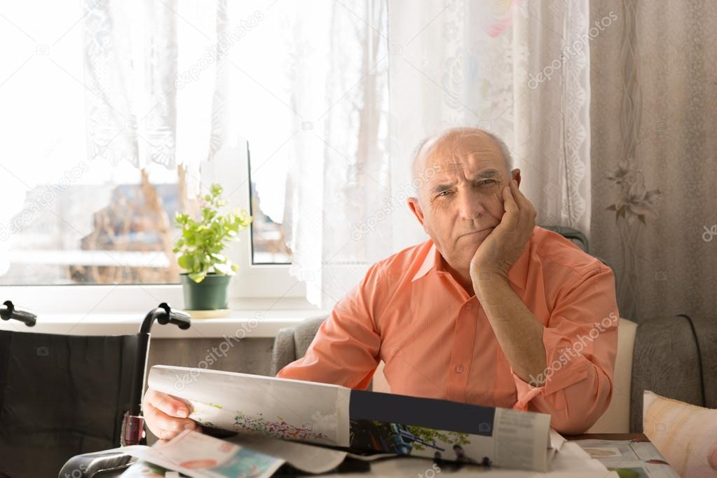 Old Man with Newspaper Looking at the Camera