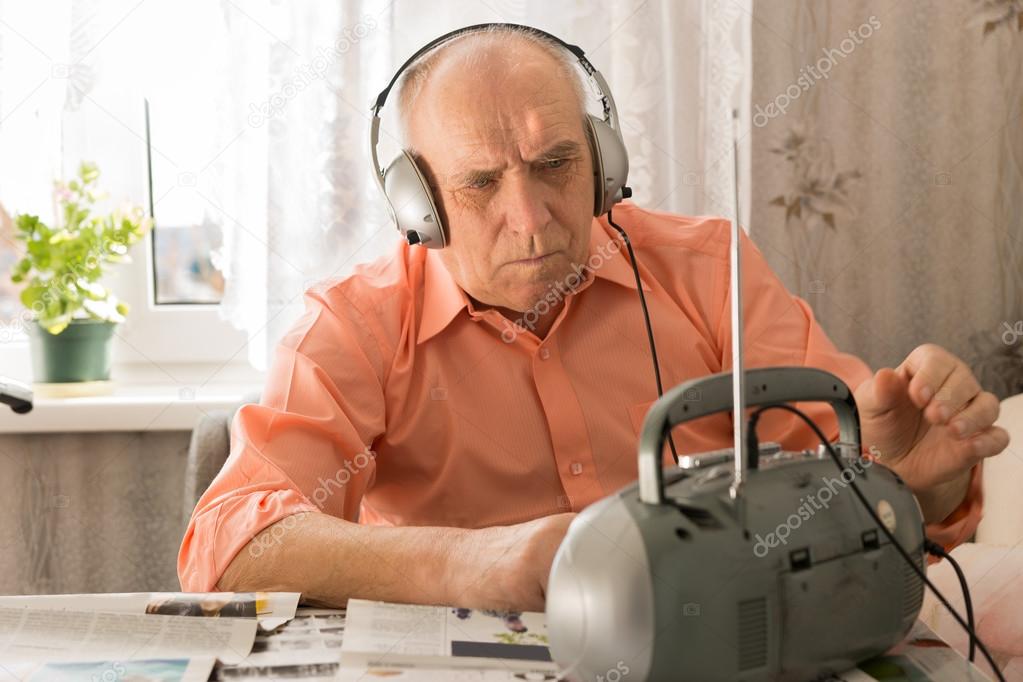 Serious Old Man Listening at Cassette Player