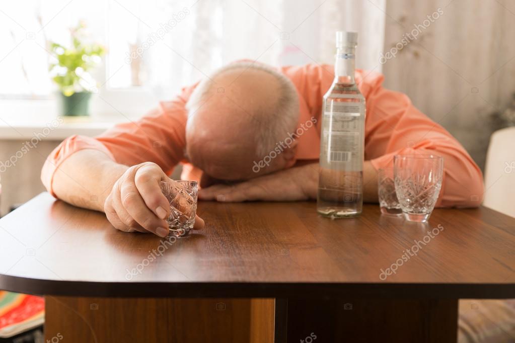 Drunk Old Man Leaning on the Table Holding a Glass