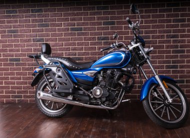 Tuğla duvar önünde mavi Cruiser motosiklet