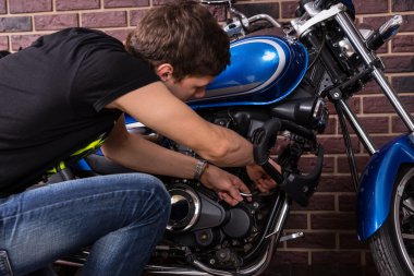 Genç adam onun motosiklet el ile onarma
