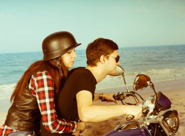 Retro çift sahilde bir motosiklet sürme