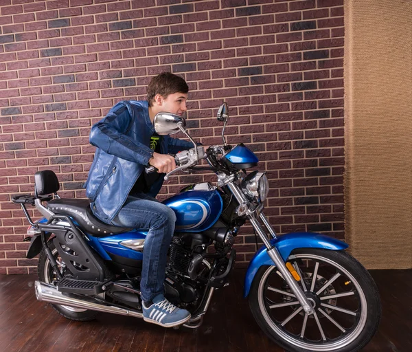 Joven con chaqueta azul en su moto deportiva — Foto de Stock