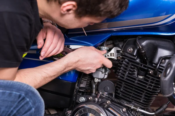 Man aan het werk op zijn motorfiets met behulp van moersleutel Tool — Stockfoto