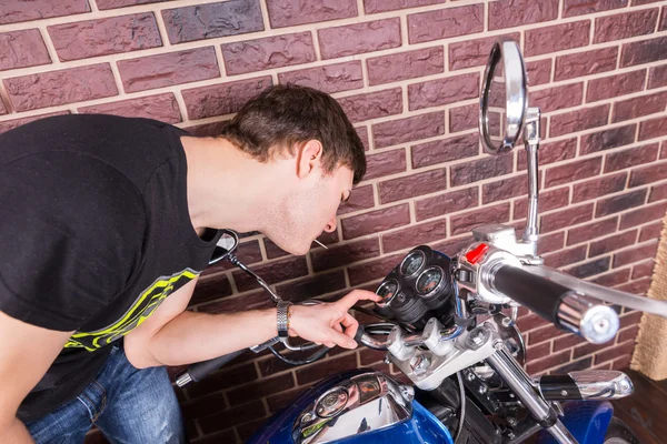 Jovem Examinando minuciosamente medidores na motocicleta — Fotografia de Stock