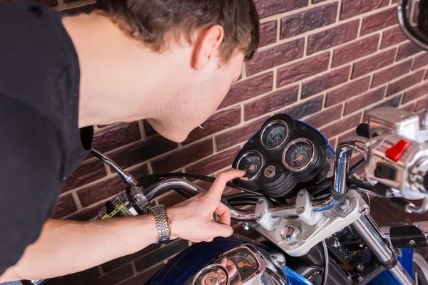 Young Man Closely Examining Gauges on Motorcycle — Stock Photo, Image