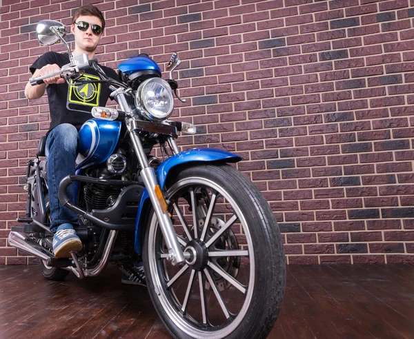 Joven sentado en la clásica motocicleta azul — Foto de Stock