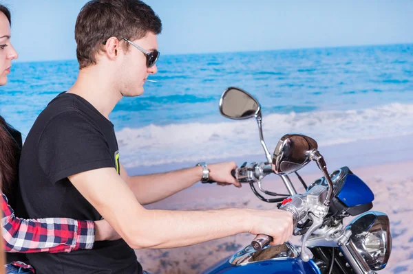 Ungt par ridning motorcykel på stranden — Stockfoto