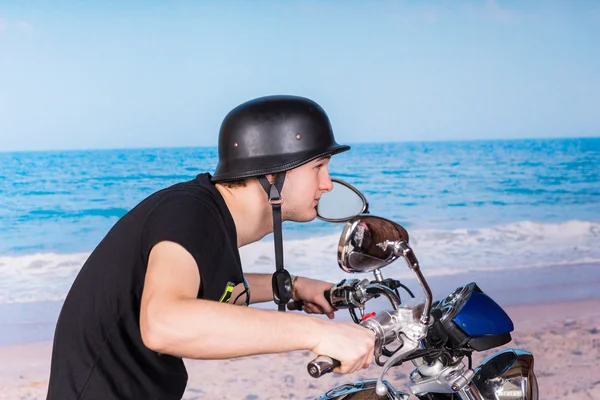 Мужчина на мотоцикле на пляже в шлеме — стоковое фото