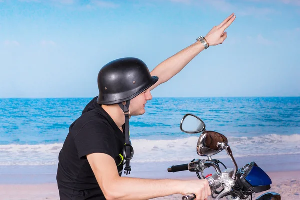 Jovem de capacete saudando enquanto anda de bicicleta — Fotografia de Stock