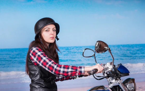 Mujer en moto en la playa mirando a la cámara —  Fotos de Stock