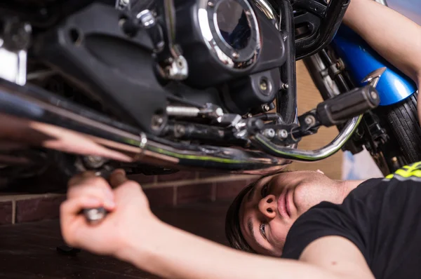 Jovem fazendo manutenção em sua moto — Fotografia de Stock