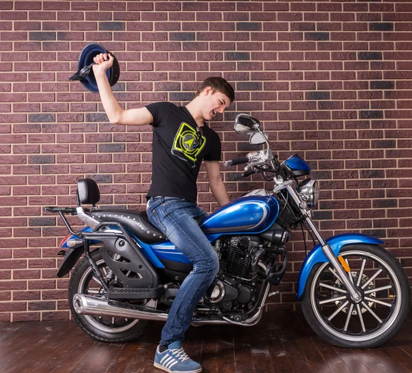 Irritado homem batendo sua moto usando um capacete — Fotografia de Stock