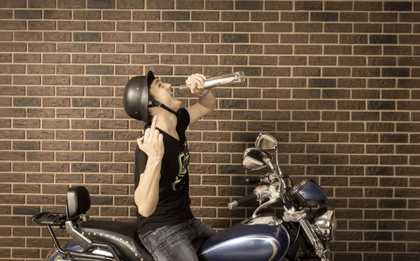 Hyped up motorcyclist sitting drinking alcohol — Stock Photo, Image