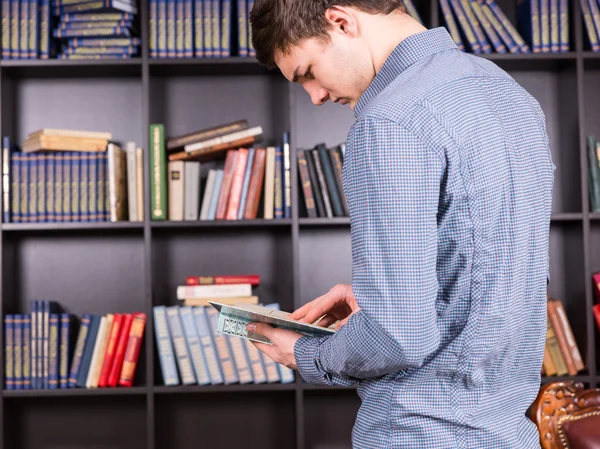 Junger Mann sucht Informationen in einem Buch — Stockfoto