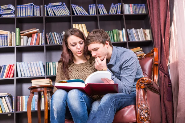 Doce casal jovem em uma cadeira Literatura de leitura — Fotografia de Stock