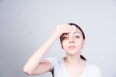 Young Woman Applying Astringent on Forehead clipart
