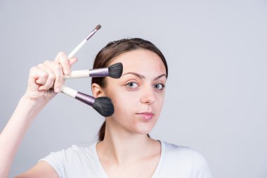 Makyaj fırçaları farklı boyutlarda tutan kadın