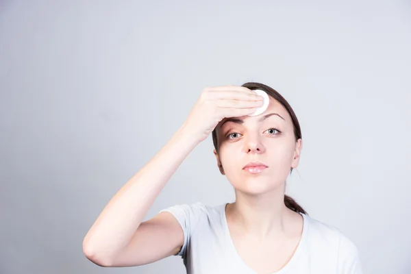 Jovem mulher aplicando Astringente na testa — Fotografia de Stock