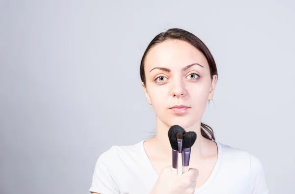Donna che tiene pennelli per il trucco come il microfono — Foto Stock