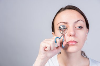 Kadın onun Lashes kullanarak kirpik kıvırıcı sıkma